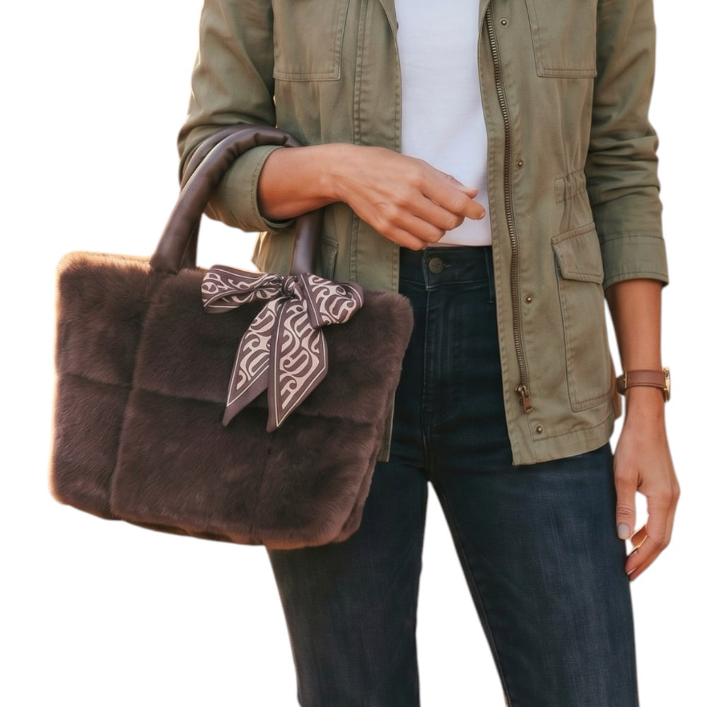 a close up of a bag held in the crook of a woman's arm