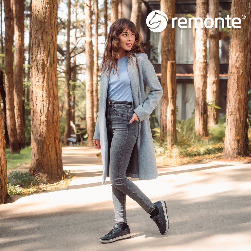 Image of a woman walking in the forest wearing Remonte trainers