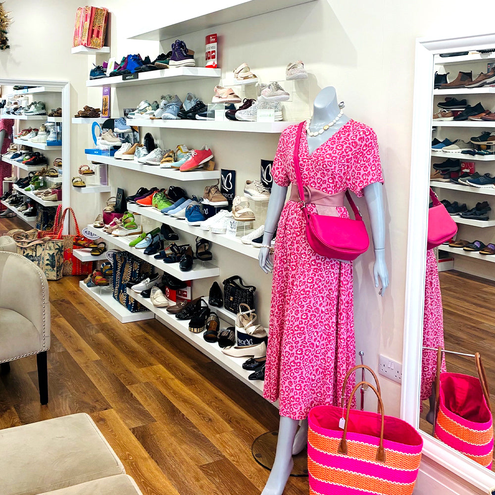 Image of the interior of the Tania Dolores store in Ramsey, showing a dress, shoes, bags and accessories