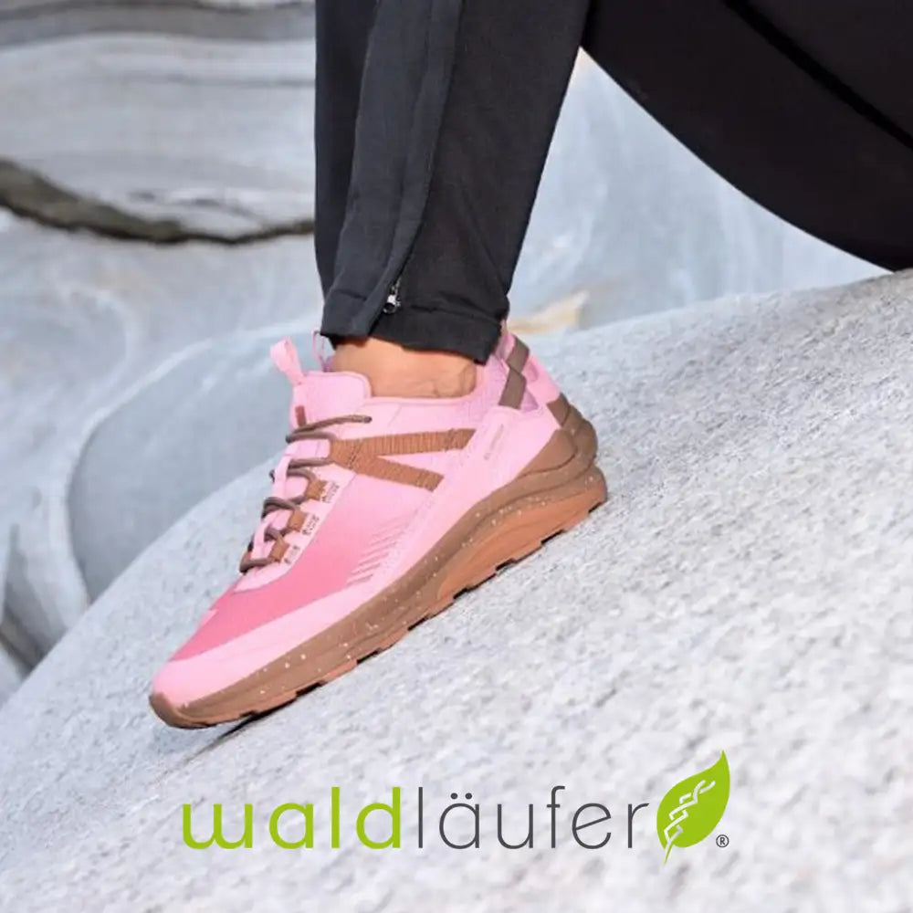 Pink and brown sneaker on a rocky surface with 'waldüläufer' branding.