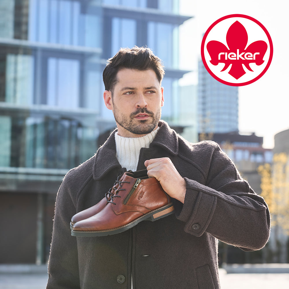 Image of a man holding brown Rieker boots